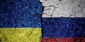 Cracked Ukrainian and Russian flags painted on concrete.