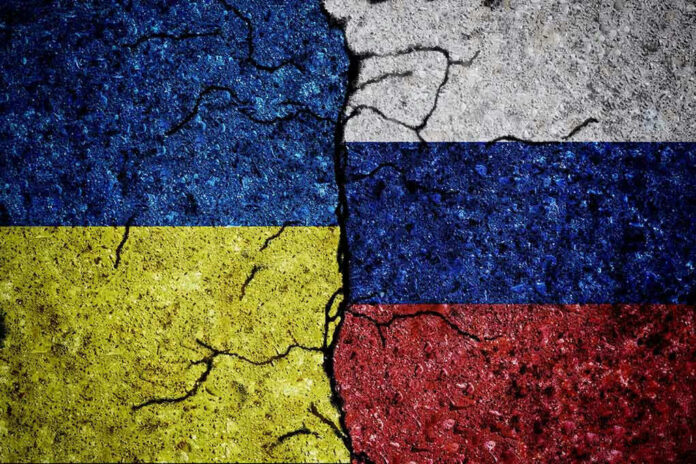 Cracked Ukrainian and Russian flags painted on concrete.