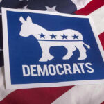 Dem Aide ARRESTED – Facing Federal Charges! Democrats logo on American flag background