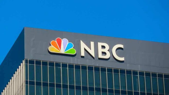 NBC logo displayed on a corporate building against a blue sky