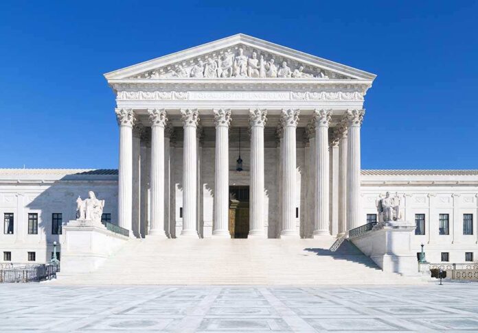 The Supreme Court building featuring marble columns and a clear blue sky