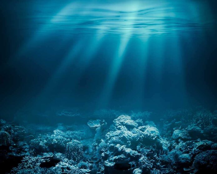 Underwater view of a coral reef with light rays penetrating the water