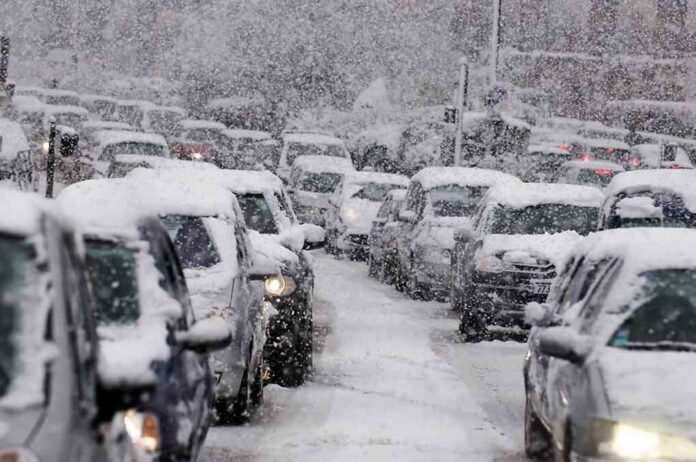 Traffic jam with cars covered in heavy snow during a snowstorm