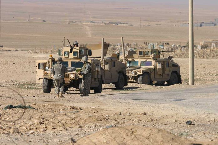 shutterstock_76580419.jpg Two military humvees with soldiers in a desert landscape