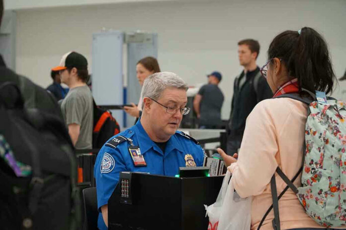 TSA agent checks passengers documents at airport security.
