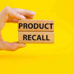 Emergency Recall Alert – Parents Worst NIGHTMARE Hand holding Product Recall blocks on yellow background.