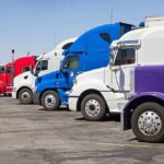 Truckers FLEE California – Stricter Rules Ignite Exodus A lineup of colorful trucks parked in a lot