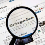 Magnifying glass over The New York Times website.