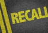 Yellow RECALL text on asphalt background.
