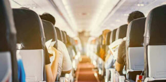 Passengers seated inside an airplane cabin.