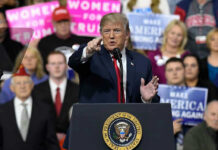 Rally Outrage Erupts Over Trump’s Rally Introducer Person speaking at rally with crowd behind podium
