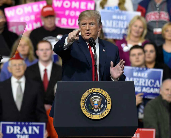 1046190946 Person speaking at rally with crowd behind podium