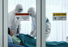 Ebola SURGE – Numbers Don’t Add Up! Healthcare workers in protective gear in quarantine room.