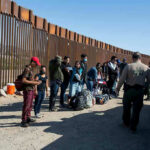 Self-Deportation Surge: Trump Breaks Record! Border patrol agents interact with a group of people.