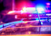 Close-up of police car lights flashing at night.