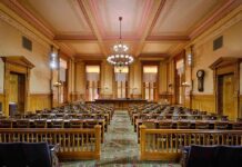Courtroom Birth SHOCKER: Pregnant Woman Chained Interior view of a historic courtroom with wooden furnishings and chandeliers