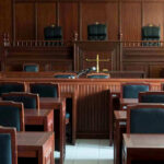 Empty courtroom with wooden furnishings and judges bench.
