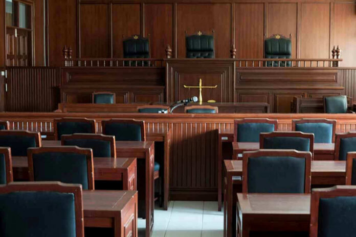 1154521519-2 Empty courtroom with wooden furnishings and judges bench.