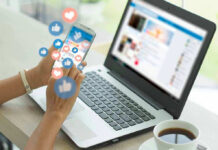 Person using smartphone and laptop with social media icons.