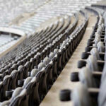 Father FALLS To Death During Concert! Empty rows of gray seats in a stadium.