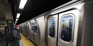 A commuter waiting at a subway station as a train approaches
