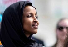 Half Of All Migrants In MN Have Committed Immigration Fraud! Woman wearing a black hijab looking thoughtfully into the distance