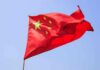 China Takes U.S Citizen HOSTAGE! Chinese flag waving against a clear blue sky