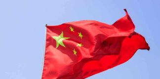 Chinese flag waving against a clear blue sky