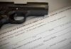 A handgun placed on top of a concealed carry license application form