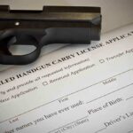 A handgun placed on top of a concealed carry license application form