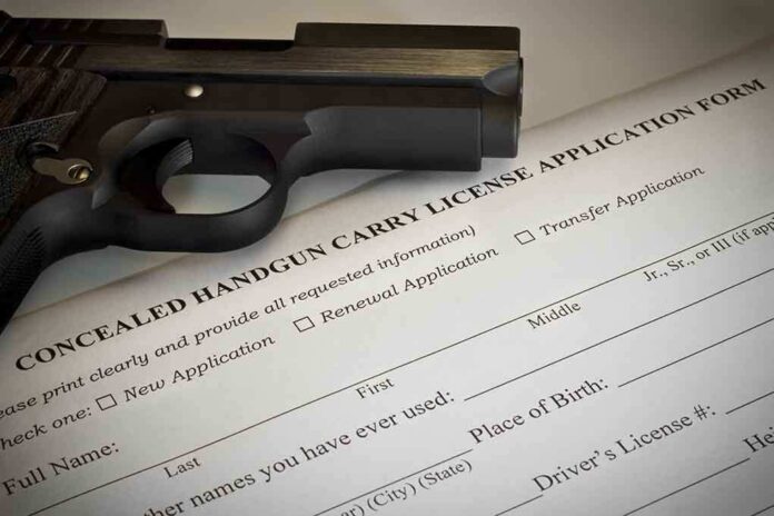 A handgun placed on top of a concealed carry license application form