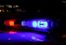 Circuit Judge CHARGED After Shocking Assault! Close-up of police lights flashing in blue and red at night