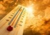 Air-Conditioning War BREAKS OUT Amid Deadly Heatwave! A thermometer displaying temperature against a sunset sky