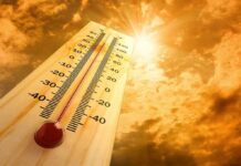 Air-Conditioning War BREAKS OUT Amid Deadly Heatwave! A thermometer displaying temperature against a sunset sky
