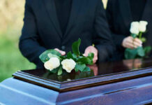 Trump’s FAVORITE Musician Passes Away Aged 74 People placing white roses on a casket.