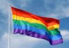 LQBTQ Cruise DENIED Entry to European Port! A rainbow flag waving against a blue sky