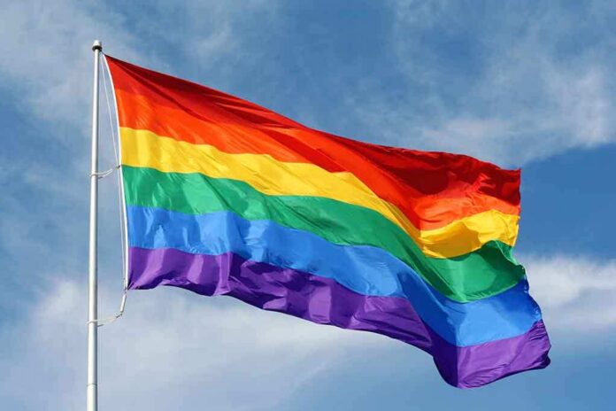 shutterstock_115334461 A rainbow flag waving against a blue sky