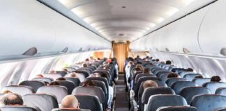 Airplane cabin with passengers seated in rows
