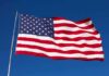Rising Dem Star TRASHES U.S Flag During Campaign Rally Waving American flag against a clear blue sky