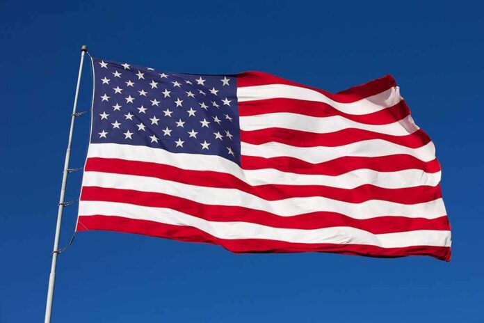 Rippled,Us,Flag,On,A,Windy,Day Waving American flag against a clear blue sky