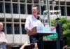 ICE Raids Newsom Press Conference Man speaking at a rally podium outdoors