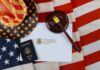 U.S. passport, gavel, and USCIS document on American flag