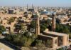Lt. Governor Aims to BLOCK Public Muslim Prayers Aerial view of a city featuring traditional buildings and minarets