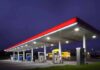 Fuel Fines Hit Gas Stations: Hundreds on the Hook! A gas station at night with illuminated fuel pumps and a convenience store