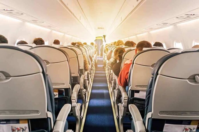 shutterstock_1196036986 airplane cabin with passengers seated in economy class
