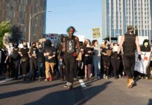 BLM Protests Erupt Right in Time For The Midterms Protesters march down a city street holding signs