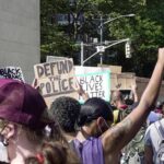 Shock Move: Chauvin Conviction On The Line crowd at a protest holding signs and raising fists
