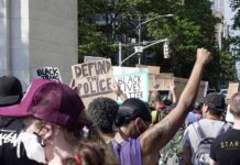Shock Move: Chauvin Conviction On The Line crowd at a protest holding signs and raising fists