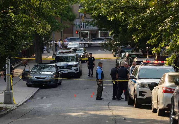 shutterstock_2330301305 Police officers secure a residential street with patrol cars and yellow tape