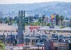 Trump Suspends Travel To Border Cities Amid Chaos Border crossing booths at Mexico entry point with cityscape in background